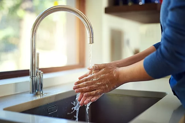 Woman washes hands before caring for a central line at home